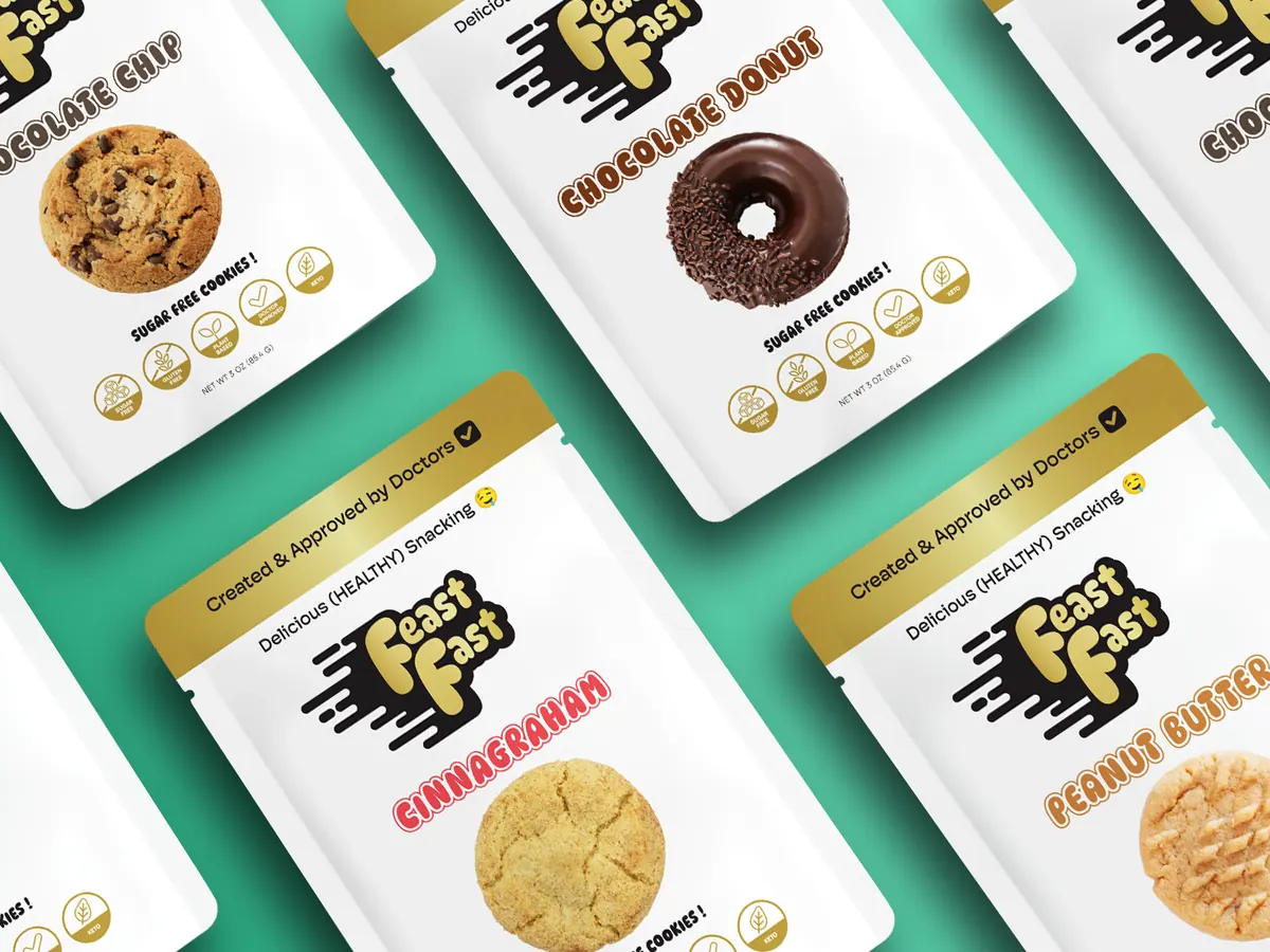 Diagonal rows of FeastFast cookie pouches, including chocolate chip, chocolate donut, CinnaGraham and peanut butter, on a mint-teal background.